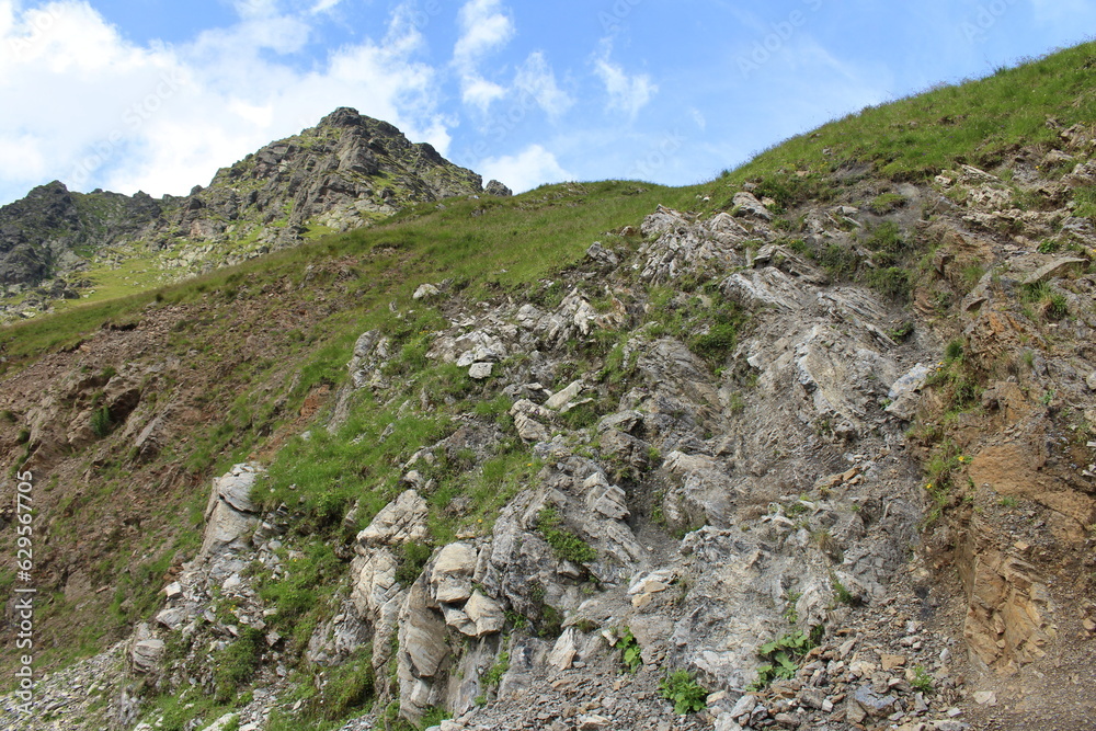 A rocky hill with grass and rocks