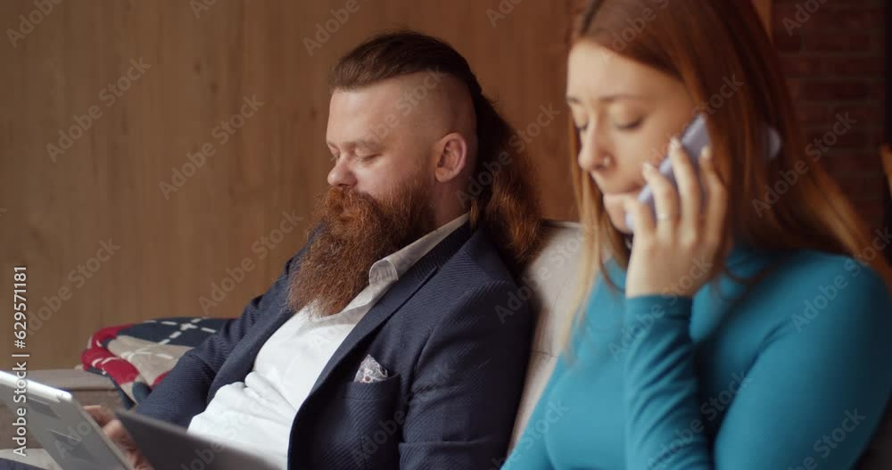 Male manager with long beard checking the data on a tablet pc while having a meeting with his colleagues, teal and orange, trucking Male manager with long beard checking the data on a tablet pc while having a meeting with his colleagues, teal and orange, trucking
