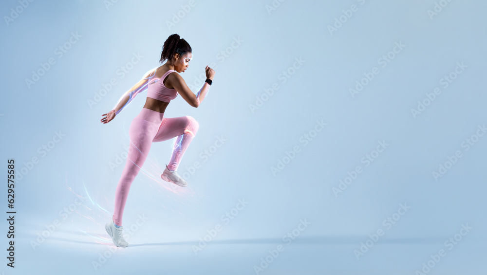 Motivated young african american athletic woman running over blue background Motivated young african american athletic woman running over blue background