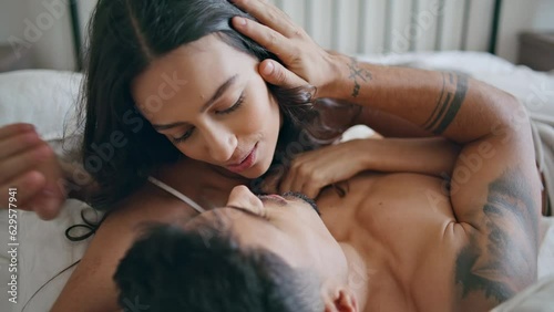 Gentle woman kissing husband bedroom close up. Married couple enjoying together