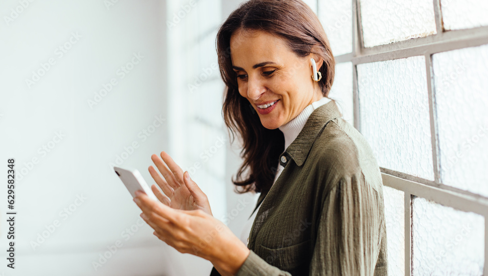 Female professional video calling her business colleagues with a smartphone Female professional video calling her business colleagues with a smartphone