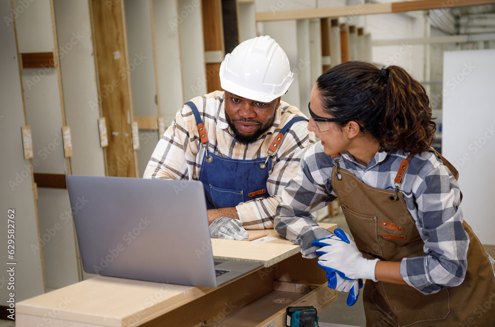 Team of professional carpenters men and women laptop computers in education and design Crafting furniture in the factory Team of professional carpenters men and women laptop computers in education and design Crafting furniture in the factory