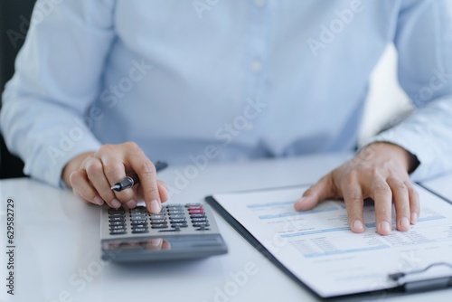 Businesswoman Accountant analyzing investment charts Invoice and pressing calculator buttons over documents. Accounting Bookkeeper Clerk  Bank Advisor And Auditor