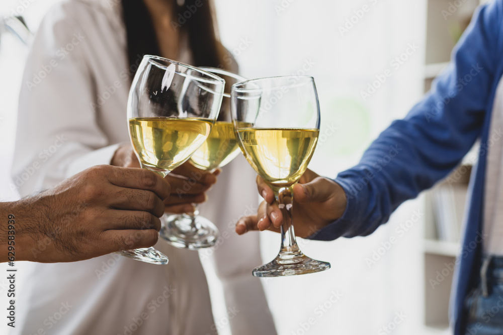 Cheers, clink glasses, Friends having a drink to celebrate at a small party in their home office. Cheers, clink glasses, Friends having a drink to celebrate at a small party in their home office.