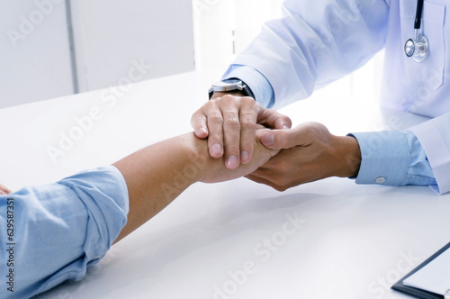 Doctor holding patient s hand  and reassuring his male patient helping hand concept   