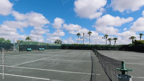 tennis courts in tropical setting sunny day pan left