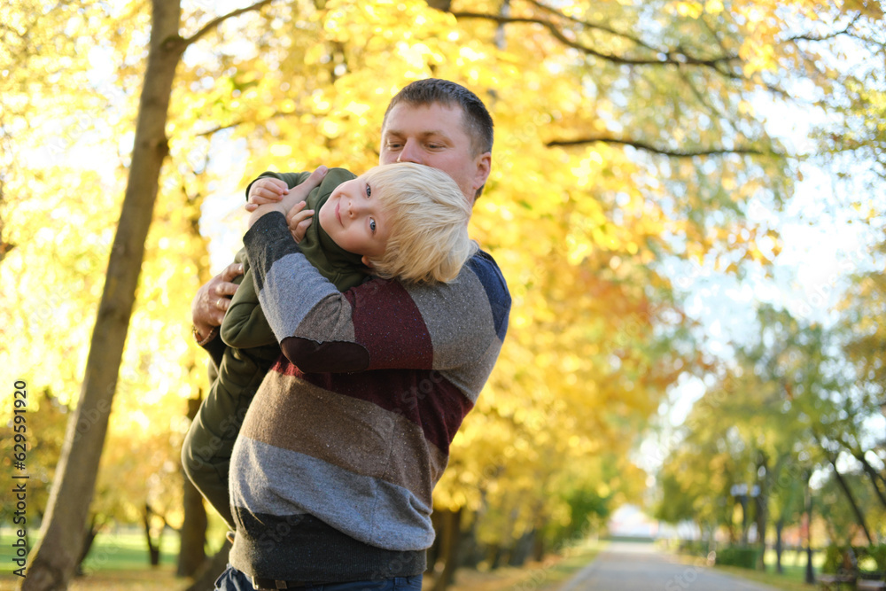 Father playing with son in autumn park Father playing with son in autumn park
