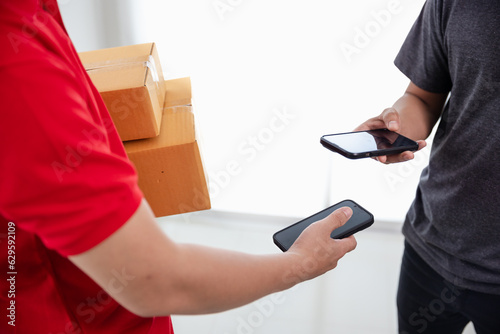 A man in a red t-shirt is delivering a package to a satisfied customer. Friendly staff, high quality delivery service.