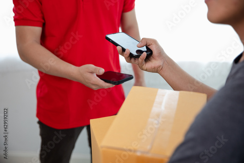 Delivery man holding a stack of cardboard boxes send parcels to customers