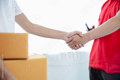 Delivery man holding a stack of cardboard boxes send parcels to customers