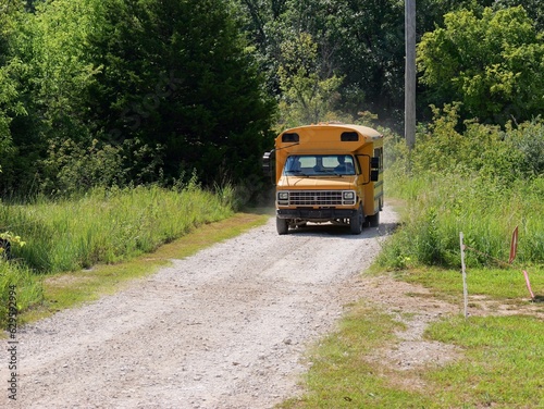 Old school bus on rural gravel road photo