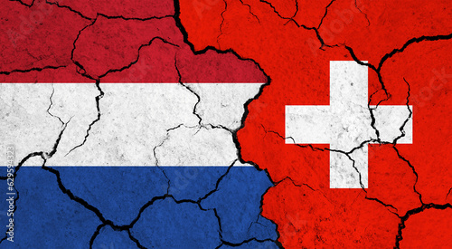 Flags of Netherlands and Switzerland on cracked surface - politics, relationship concept