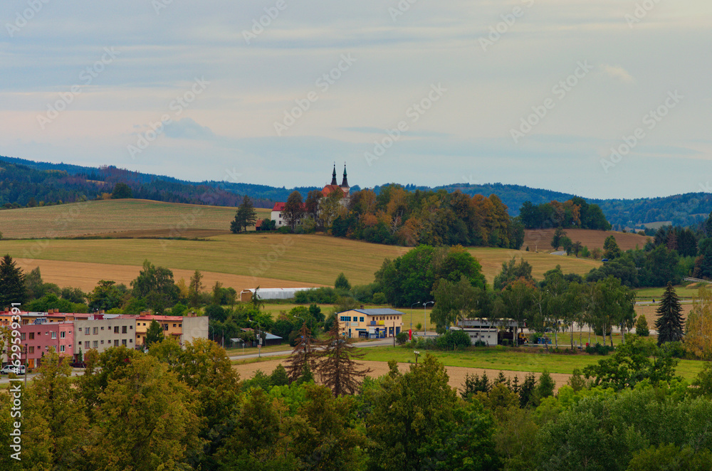 Typical aerial landscape view of the Czech Republic. Buildings with red tile roofs, agriculture fields and forest in the background. Small town in the Czech Republic. Travel and tourism concept