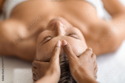 Closeup of hands massaging beautiful woman s face at spa salon