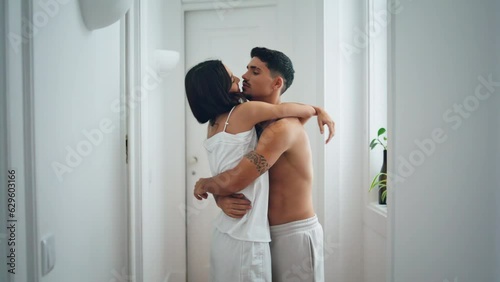 Sensual couple embracing cozy home hall. Half naked man cuddling cute woman