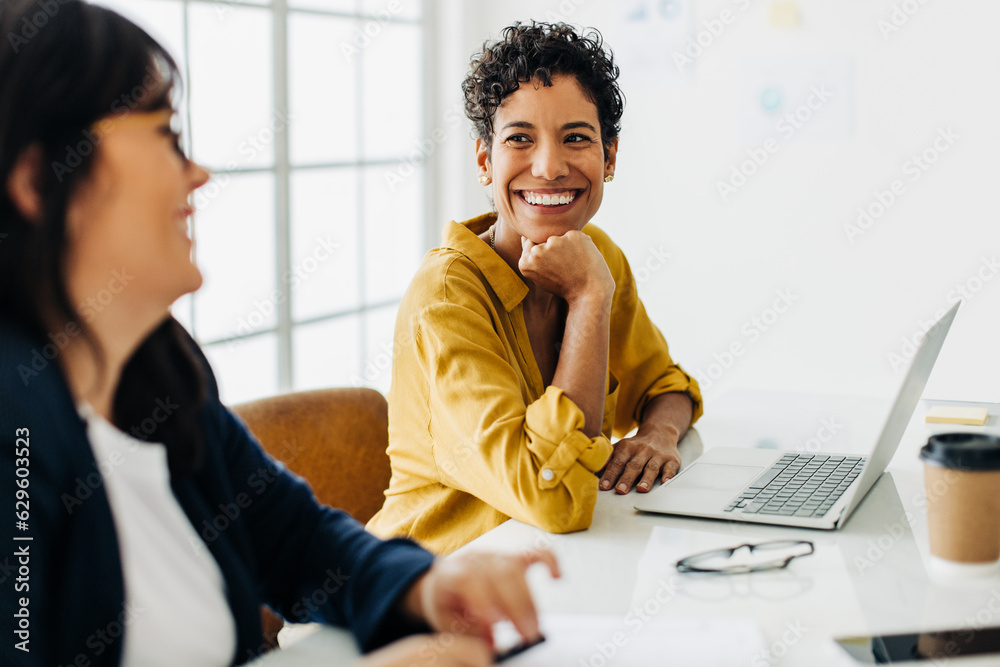 Happy business woman talking to her colleague in a meeting - obrazy, fototapety, plakaty 