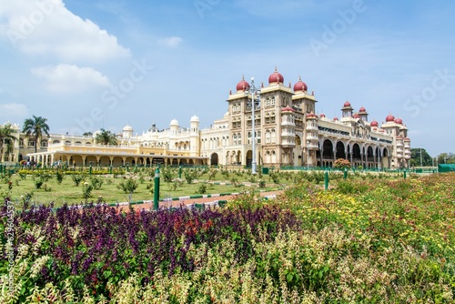 Closeup of a historical Amba Vilas Palace surrounded by lush flower beds in India