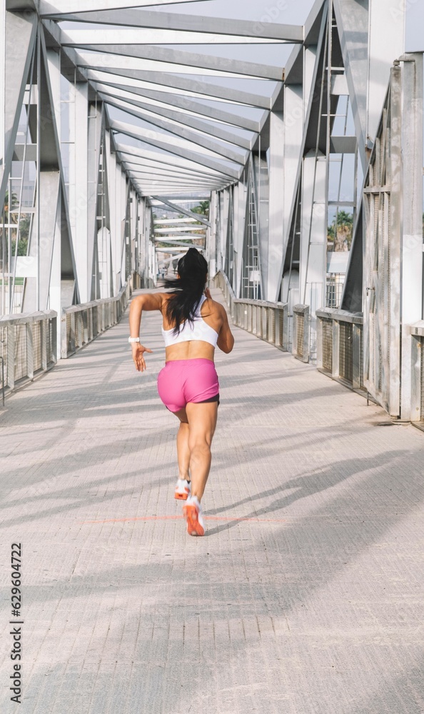 Young female in sporty clothes running in street Young female in sporty clothes running in street