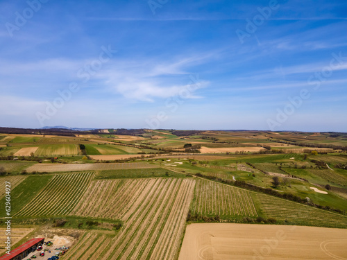 Aerial drone view in early spring of wine country with a golf course in the foreground during the day with scattered clouds in Poysdorf, Lower Austria, Austria. photo