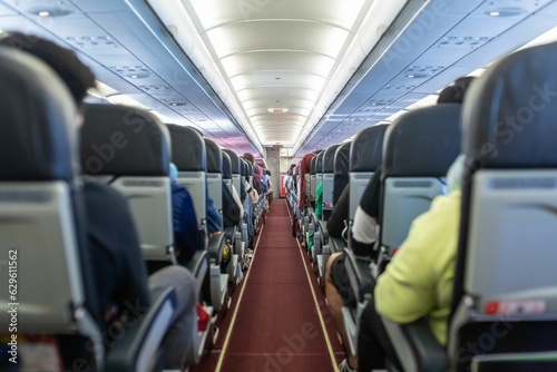 A photograph of passengers traveling by a plane, shot from the inside of an airplane