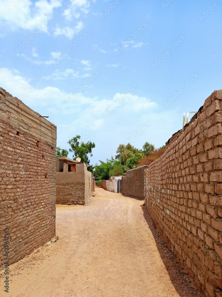 View of brick facades on sandy street of Dahab in the Sinai desert. Traditional houses of Egyptian seaside town. Arab culture and Red Sea. Architecture and construction. View of brick facades on sandy street of Dahab in the Sinai desert. Traditional houses of Egyptian seaside town. Arab culture and Red Sea. Architecture and construction.