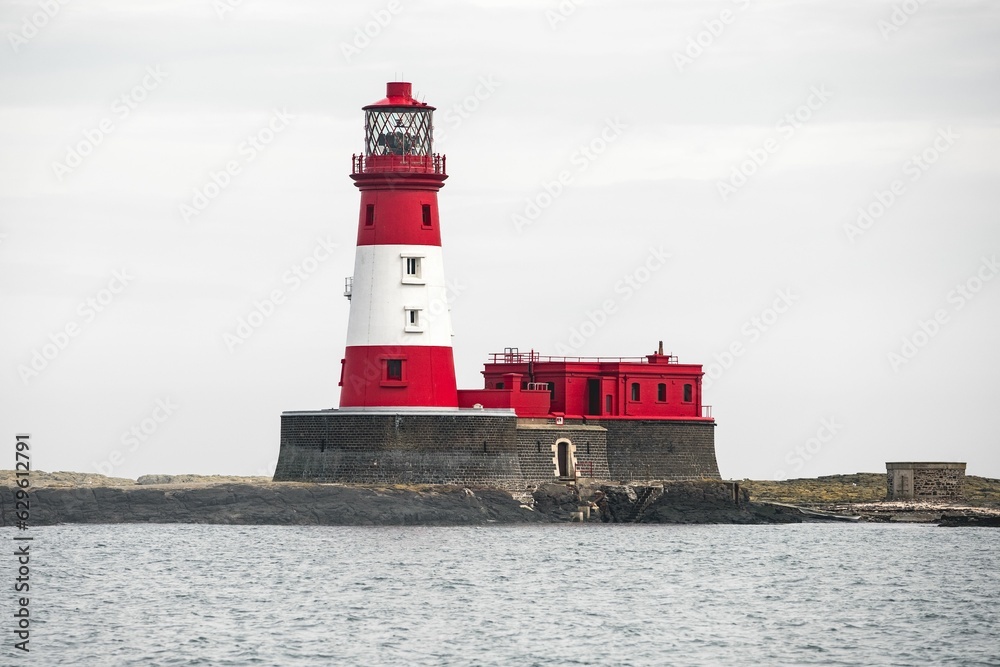 a large white and red lighthouse with a tower on top of it