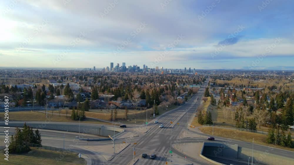 Drone view over crossroads and highways between residential areas with a background of a cityscape Drone view over crossroads and highways between residential areas with a background of a cityscape