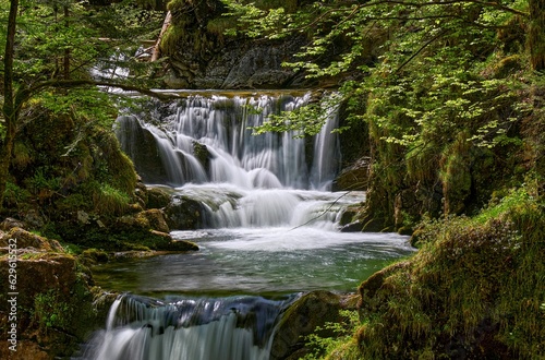 Spectacular view of Rottach Waterfall in Bavaria, Germany, with lush green trees in the background
