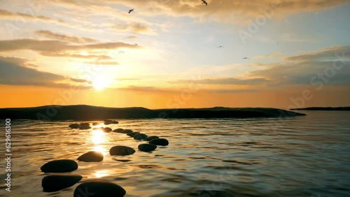 A camera moves slowly over stepping stones at sunset as birds fly high in the golden sky.