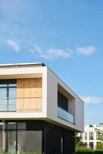 Fototapeta Corner of two storey house or cottage with balconies and large windows standing