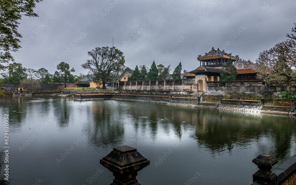 Panoramic view of the majestic Imperial City in Hue, Vietnam, with a body of water and lush greenery