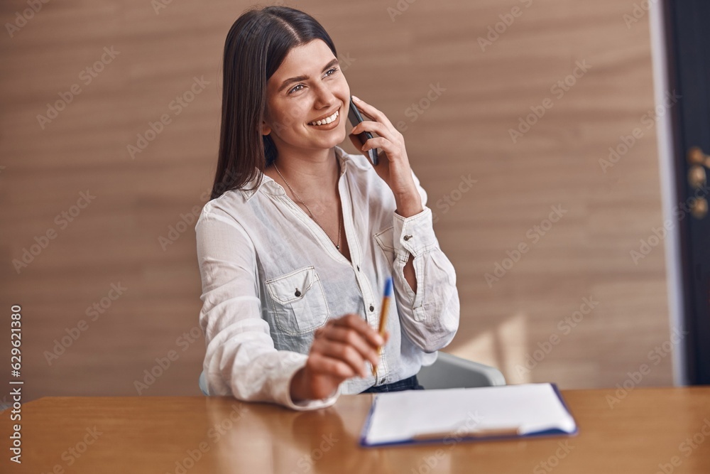 Happy smiling caucasian woman with phone and documents in modern clinic reception Happy smiling caucasian woman with phone and documents in modern clinic reception