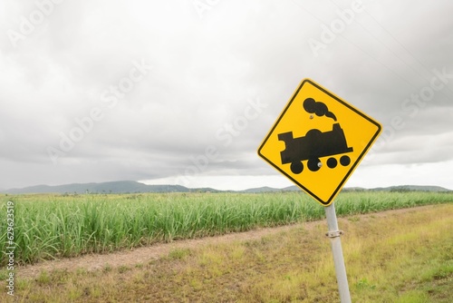 Isolated road sign depicting a road train against a backdrop of a cane field in Australia