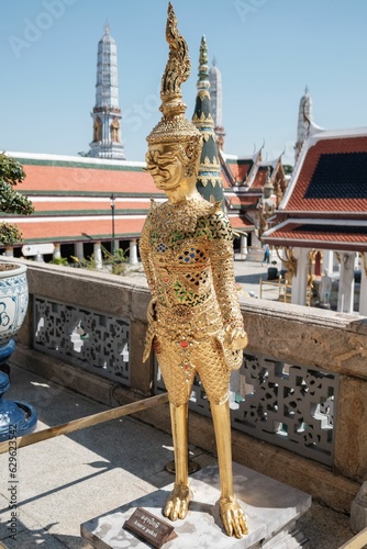 Closeup of a golden statue in The Temple of the Emerald Buddha in Bangkok