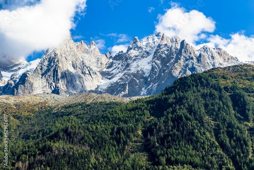 Landscape of a beautiful alpine mountain range covered in greenery on a sunny day