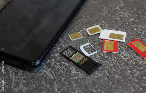 Several SIM cards and a memory card lying next to the smartphone