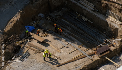 Groups of workers working at the construction site. Building foundation