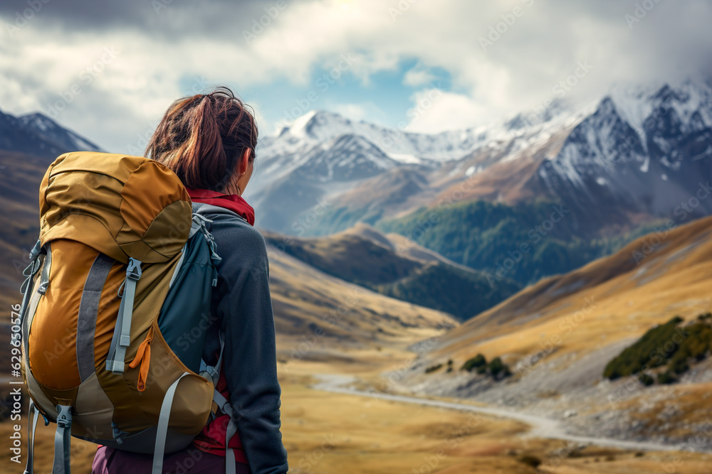 woman hiker alone with her backpack observing snow-capped mountain. Generative AI 