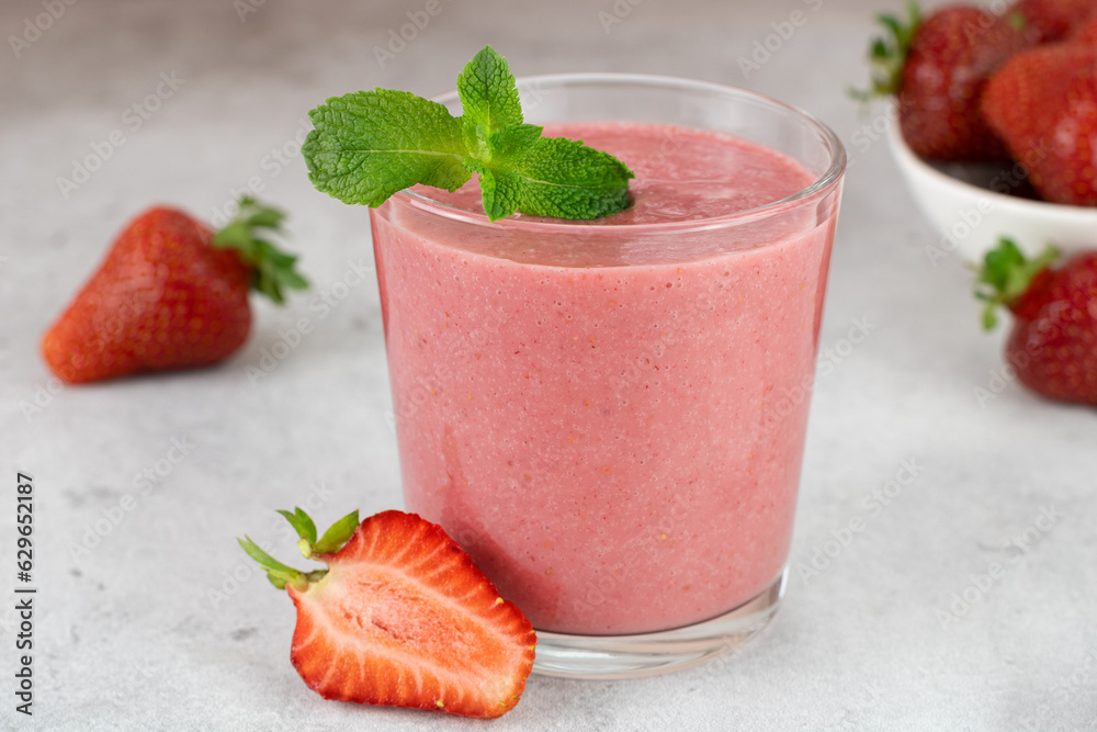 Strawberry smoothie or cocktail with berries on a gray background. Summer beverages. Strawberry smoothie or cocktail with berries on a gray background. Summer beverages.