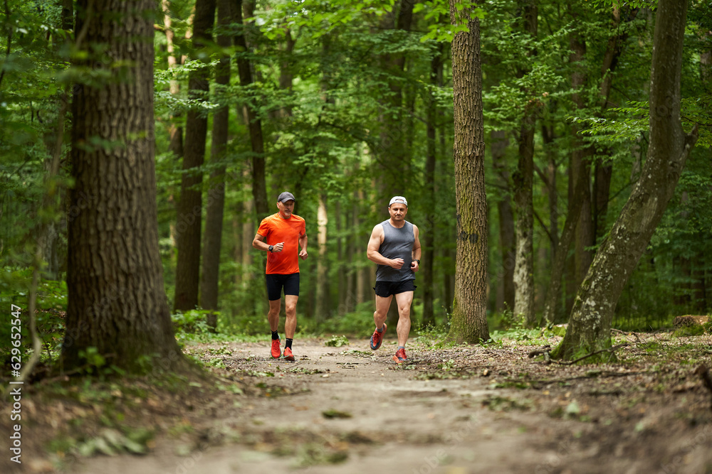 Two men running in the forest Two men running in the forest