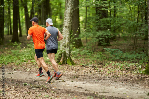 Two men running in the forest
