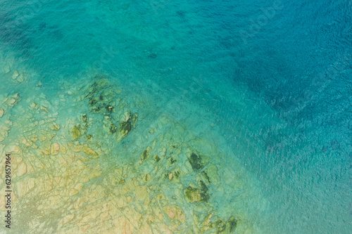 vertical aerial view of the rocky coast of garda lake near sirmione