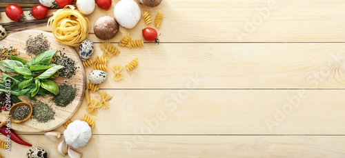 Dry pasta and different products on wooden background with space for text