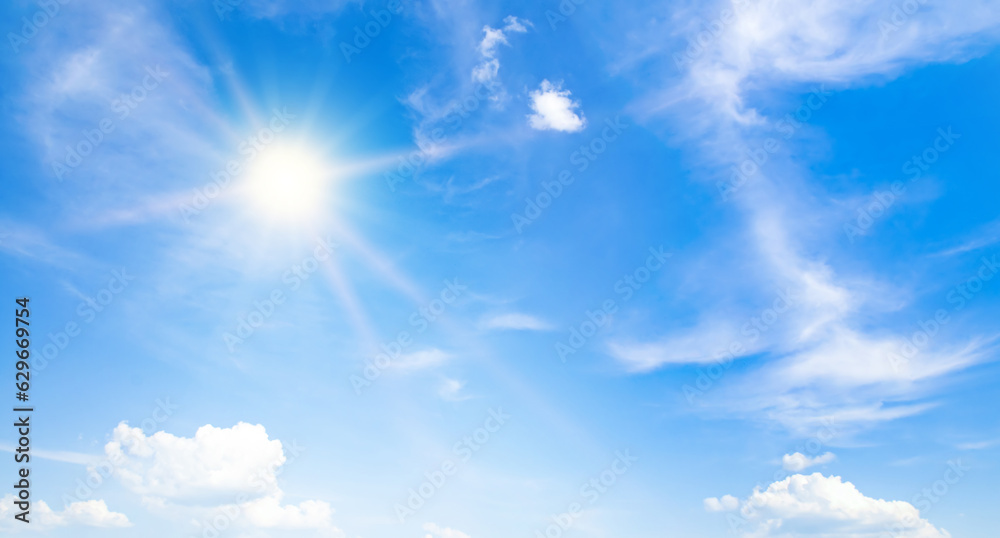 The bright sun, blue sky and clouds. Wide photo.