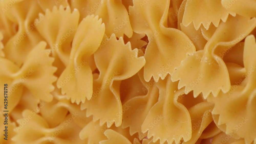 dry pasta farfalle , rotation in circle. Turning pasta background. selective focus, vertical video