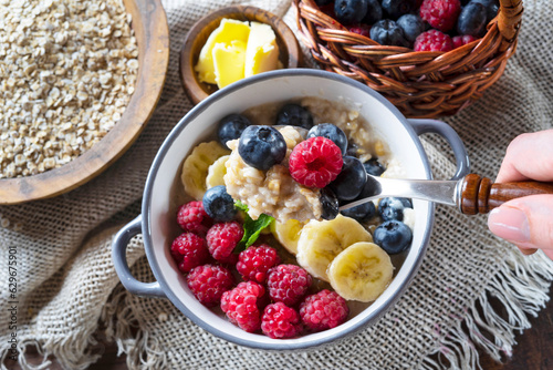 Healthy breakfast - oatmeal with banana, blueberries and raspberries.