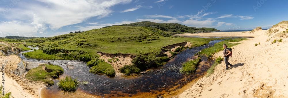 panoramic shot of woman on Kiloran Bay on the isle of Colonsay in Scotland