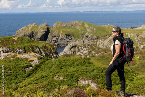 Obraz na płótnie woman hiking on the cliffs of Balnahard on the isle of Colonsay, Scotland w salonie