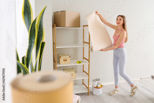Young woman holding wallpap...