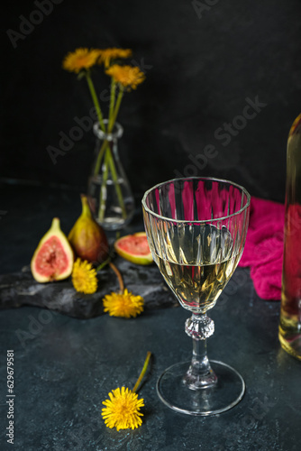 Glass of dandelion wine on dark table